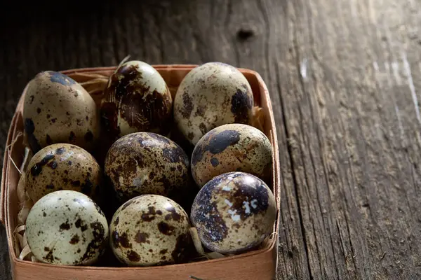 Huevos de codorniz en una caja sobre un fondo de madera vintage, vista superior, enfoque selectivo . — Foto de Stock