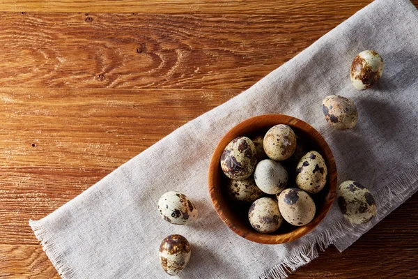 Cuenco con huevos de codorniz, huevos en una servilleta hecha en casa en la mesa de madera, primer plano, enfoque selectivo — Foto de Stock