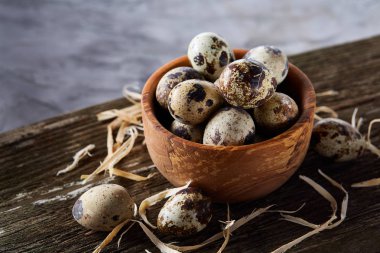 Ahşap kase bıldırcın yumurtası ahşap tahta üzerinde dolu beyaz arka plan, yakın çekim, seçici odak üzerinde.