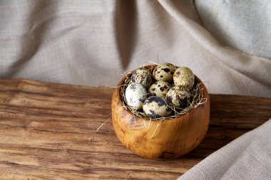 Bıldırcın yumurtası bir ahşap kase bir saf masa örtüsü, üstten görünüm, yakın çekim