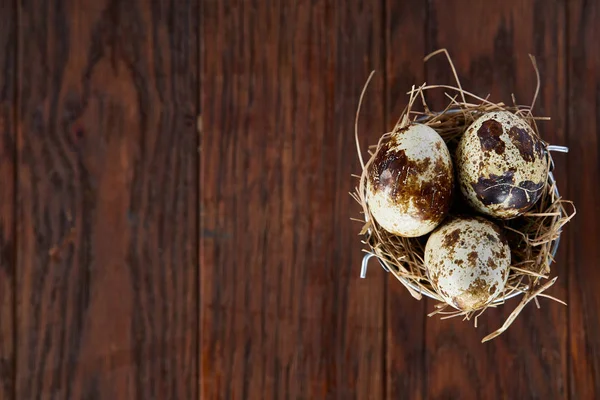 Pequeño cubo decorativo lleno de huevos de codorniz mesa de madera oscura, primer plano, enfoque selectivo . — Foto de Stock