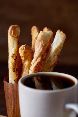 Kahve fincanı ve breadsticks bir eski ahşap arka plan, yakın çekim, seçici odak.