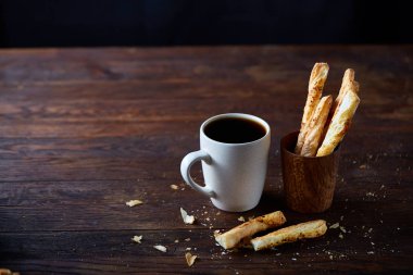 Kahve fincanı ve breadsticks bir eski ahşap arka plan, yakın çekim, seçici odak.