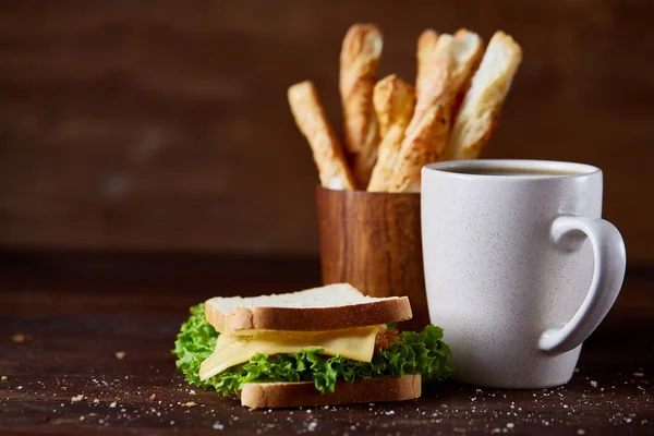 Πρωινό τραπέζι με σάντουιτς, Κριτσίνια και μαύρο καφέ ρουστίκ ξύλινα φόντο, γκρο πλαν, επιλεκτική εστίαση — Φωτογραφία Αρχείου