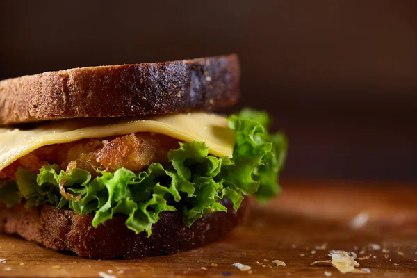 Sandwichs savoureux et frais sur planche à découper sur fond bois foncé, gros plan — Photo