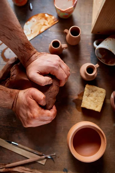 Чоловічий гончар, що формує глину в керамічній майстерні, крупним планом, вибірковий фокус, вид зверху . — стокове фото