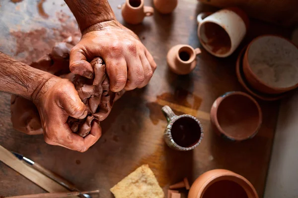 Mannelijke potter molding een klei in de pottenbakkerij, close-up, selectieve focus, bovenaanzicht. — Stockfoto