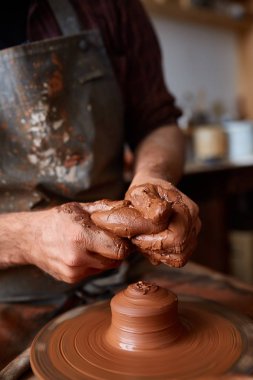 Çamurdan, seçici odak yakın çekim eller erkek Potter önlük kalıpları içinde kase