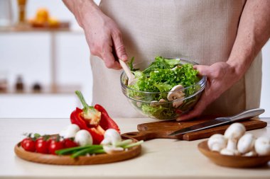Adam seçici odak sağlıklı sebze salatası, yakın çekim, yapım mutfak yemek.