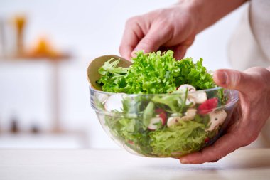 Adam seçici odak sağlıklı sebze salatası, yakın çekim, yapım mutfak yemek.
