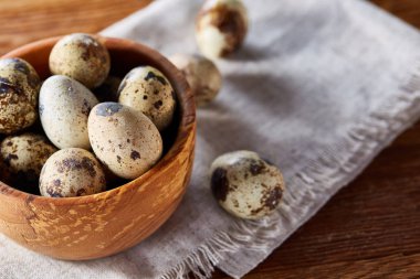 Rustik ahşap masa, yakın çekim, yüksek açılı görünüş, seçici odak kapsayıcısında bıldırcın yumurtası.