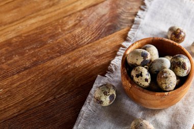 Rustik ahşap masa, yakın çekim, yüksek açılı görünüş, seçici odak kapsayıcısında bıldırcın yumurtası.