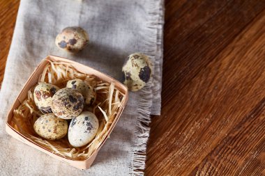 Rustik ahşap masa, yakın çekim, yüksek açılı görünüş, seçici odak kapsayıcısında bıldırcın yumurtası.