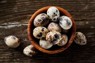 Ahşap kase bıldırcın yumurtası ahşap tahta üzerinde dolu beyaz arka plan, yakın çekim, seçici odak üzerinde.