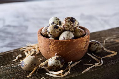Ahşap kase bıldırcın yumurtası ahşap tahta üzerinde dolu beyaz arka plan, yakın çekim, seçici odak üzerinde.