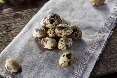 Piramit peçeteye Şimşir dalları ile düzenlenmiş bir ahşap masa, yakın çekim, seçici odak üzerinde bıldırcın yumurtası.