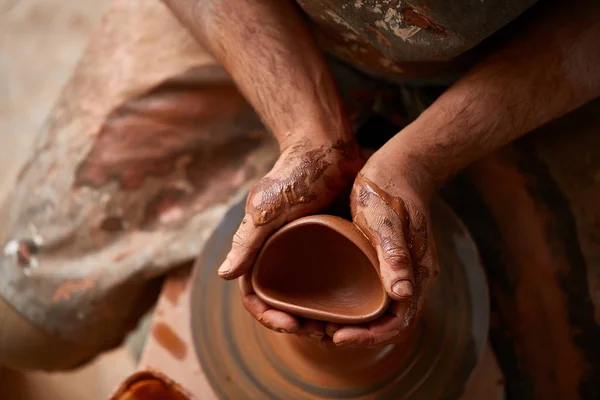 Close-up van de handen van een mannelijke potter in mallen schort kom uit klei, selectieve aandacht — Stockfoto