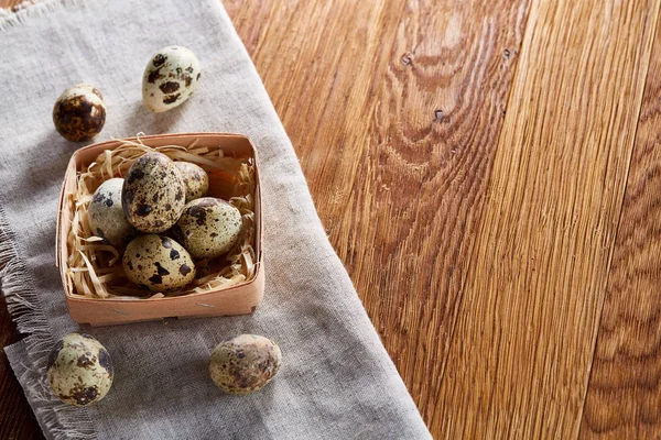 Quail eggs in the container over rustic wooden table, close-up, high angle view, selective focus. — Stock Photo, Image