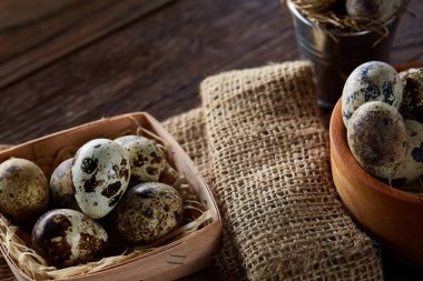 Bıldırcın yumurtası kova, kutu ve ıslak zeminde ahşap arka plan, seçici odak keten bir peçete ile rustik natürmort