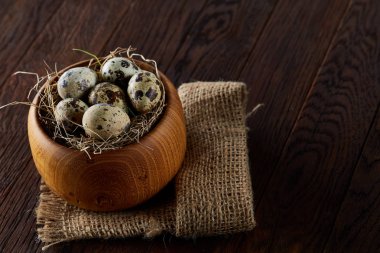 Bıldırcın yumurtası kova, kutu ve ıslak zeminde ahşap arka plan, seçici odak keten bir peçete ile rustik natürmort