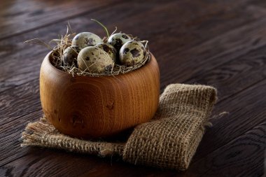 Bıldırcın yumurtası kova, kutu ve ıslak zeminde ahşap arka plan, seçici odak keten bir peçete ile rustik natürmort
