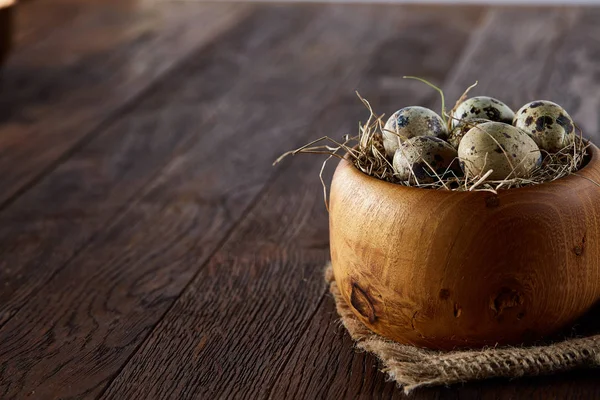 Bodegón rústico con huevos de codorniz en cubo, caja y tazón sobre una servilleta de lino sobre fondo de madera, enfoque selectivo — Foto de Stock