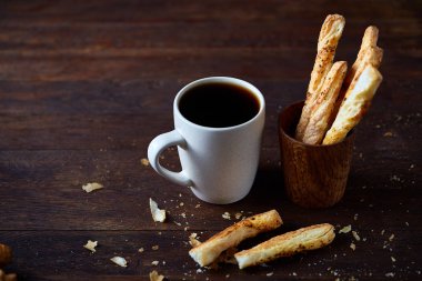 Kahve fincanı ve breadsticks bir eski ahşap arka plan, yakın çekim, seçici odak.