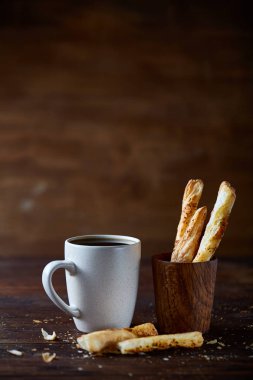 Kahve fincanı ve breadsticks bir eski ahşap arka plan, yakın çekim, seçici odak.