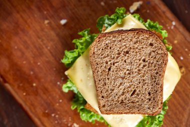 Lezzetli ve taze sandviç kesme tahtası üzerinde bir koyu ahşap arka plan üzerinde yakın çekim