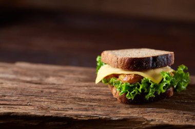 Lezzetli ve taze sandviç kesme tahtası üzerinde bir koyu ahşap arka plan üzerinde yakın çekim