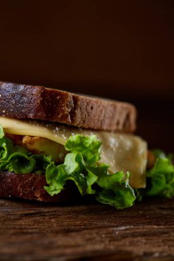 Lezzetli ve taze sandviç kesme tahtası üzerinde bir koyu ahşap arka plan üzerinde yakın çekim