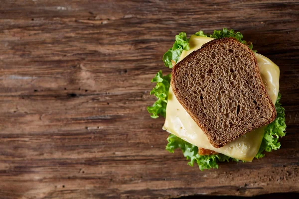 Tasty and fresh sandwiches on cutting board over a dark wooden background, close-up