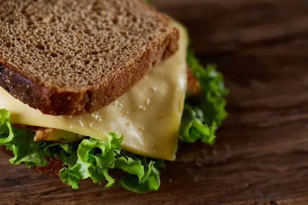 Tasty and fresh sandwiches on cutting board over a dark wooden background, close-up