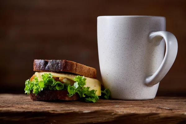 Mesa de desayuno con sándwich y café negro sobre fondo rústico de madera, primer plano, enfoque selectivo —  Fotos de Stock