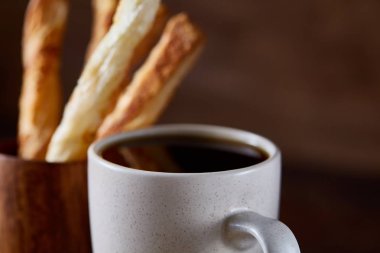 Kahve fincanı, breadsticks ve kruvasan bir eski ahşap arka plan, yakın çekim, seçici odak.