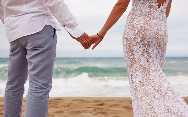 Νύφη Και Γαμπρός Κρατιούνται Χέρι Χέρι Μια Αμμώδη Παραλία — Φωτογραφία Αρχείου