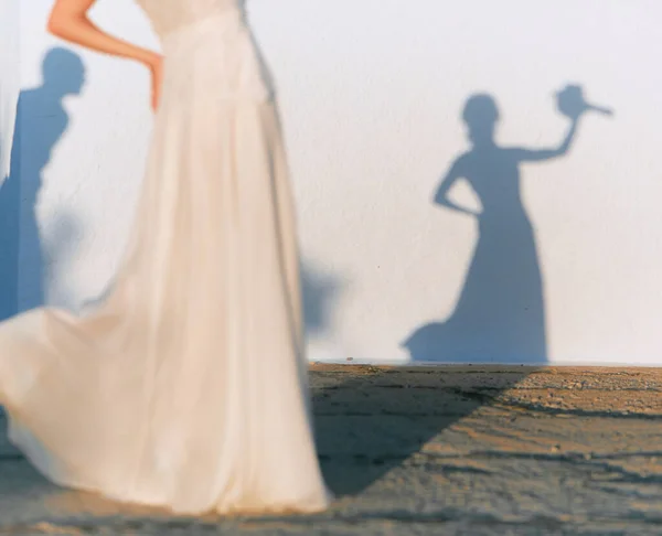 Odaklanma, beyaz bir duvarda buketi olan gelinin gölgesidir. Gelin odakta değildir..