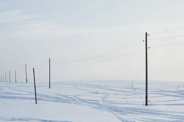 Sneeuwveld Doorkruist Door Sporen Van Passerende Auto Palen — Stockfoto