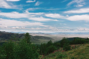 Mavi gökyüzü ve bulutları olan güzel dağlar..