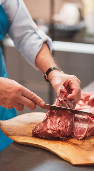 Şef bir eti bıçakla keser. Yemek pişirmek için çevre dostu ürünler kavramı. Taze, yiyecek..