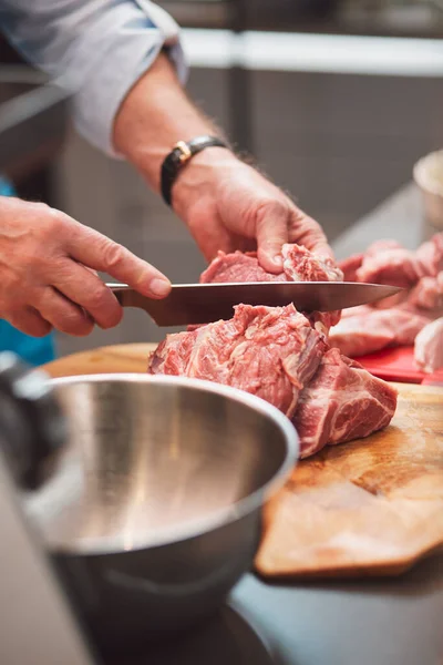 Şef bir eti bıçakla keser. Yemek pişirmek için çevre dostu ürünler kavramı. Taze, yiyecek..