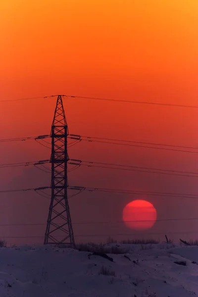 Akşamları yüksek voltajlı elektrik direği ve iletim hatları