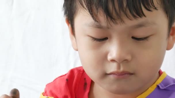 Closeup portret grappige jongen Kleurplaat, jongen bedekt met vinger verf. — Stockvideo