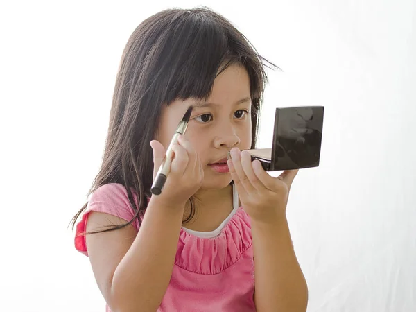 Menina brincando com as mães maquiagem e segurando espelho, olho — Fotografia de Stock