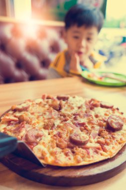 bulanık pizza ve bokeh arka plan üzerinde bulanık sevimli çocuk,