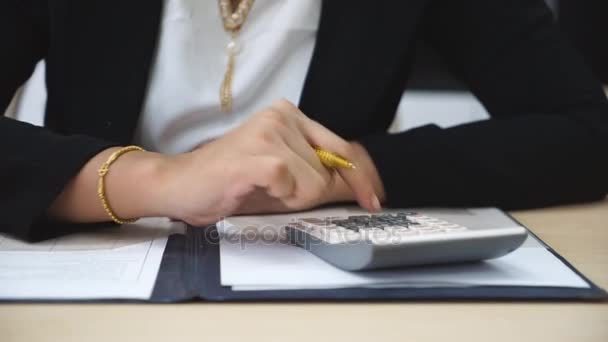 Vrouwelijke boekhouder het uitvoeren van berekeningen en het maken van notities — Stockvideo