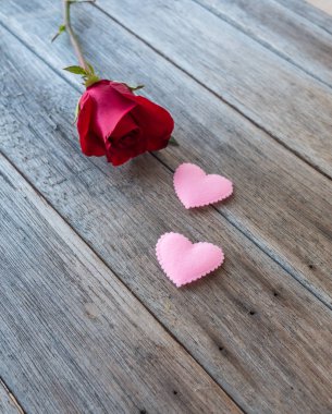 pembe Kalpler ve ahşap masa üzerinde kırmızı gül,