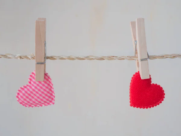 Pink heart pattern and red heart attached to a clothesline with