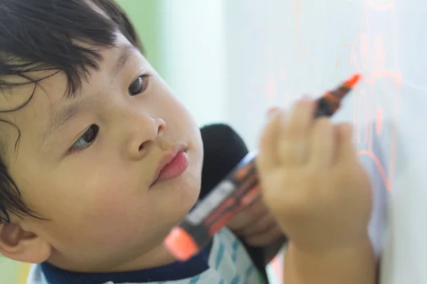 Oskärpa liten pojke skriver med en magisk penna närbild — Stockfoto