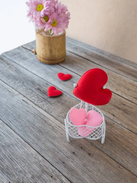 Coração em brinquedo de bicicleta e flor rosa em vaso, mesa de madeira , — Fotografia de Stock